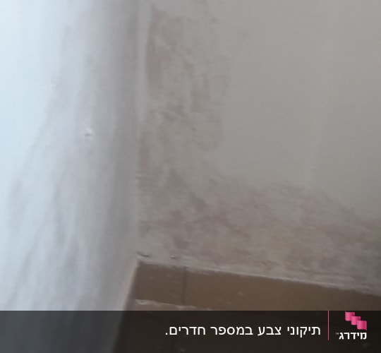קיר עם סימני צבע מתקלף ופינה לא צבועה